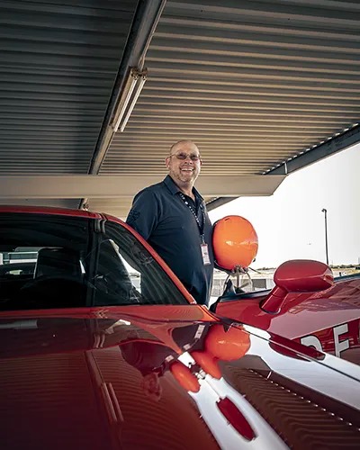 Man smiling just outside of the car