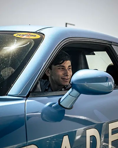 man smiling, looking out of car at Radford Racing School